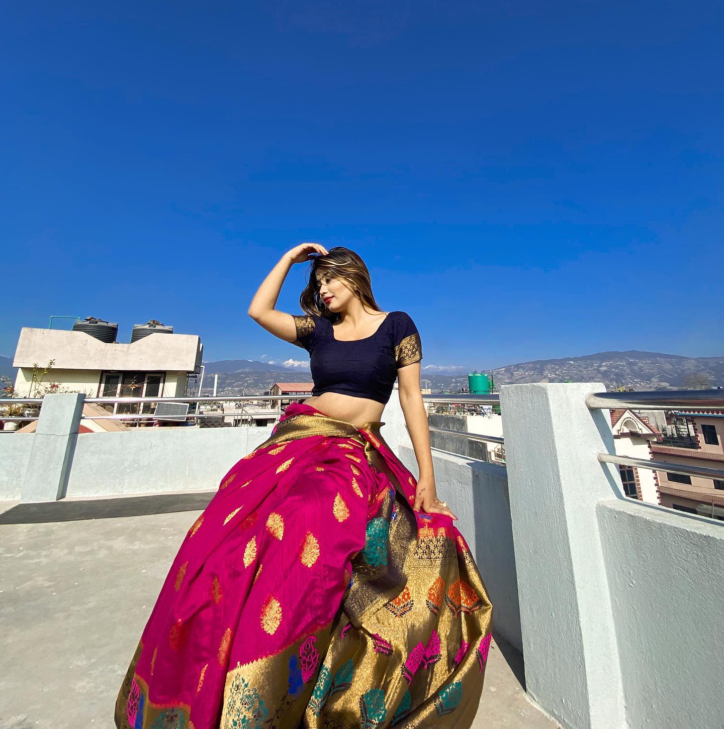 Sandhya in elegant evening attire on a rooftop