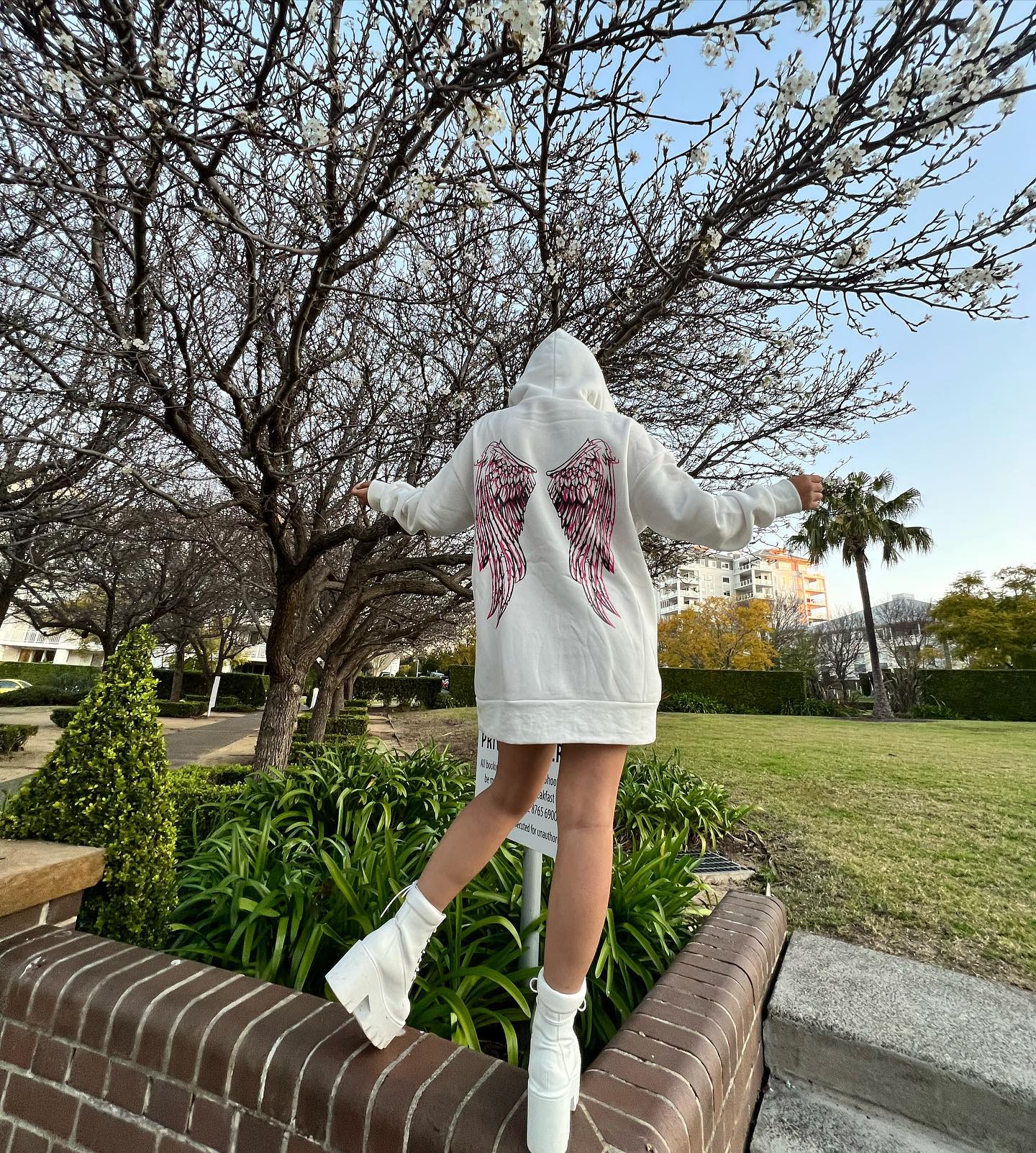 Sandhya with angel wing backdrop