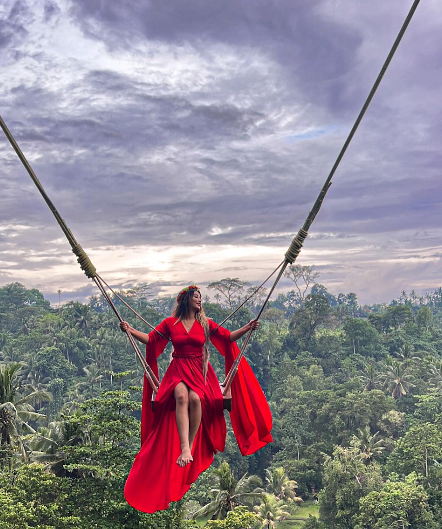 Sandhya on a jungle swing in Bali wearing a red dress